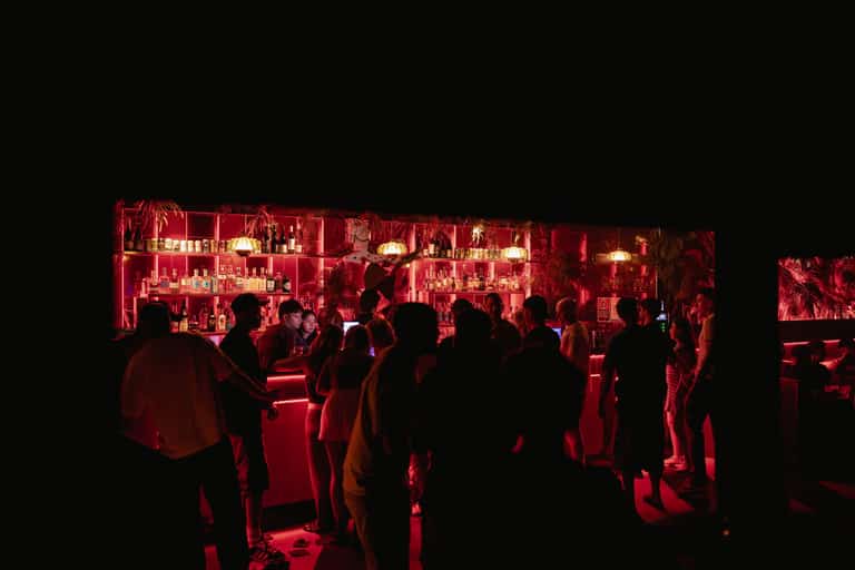 Red-lit Carousel bar with guests gathered for the night