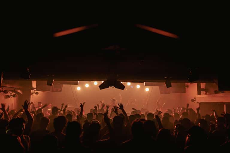 Carousel crowd facing the stage under amber haze