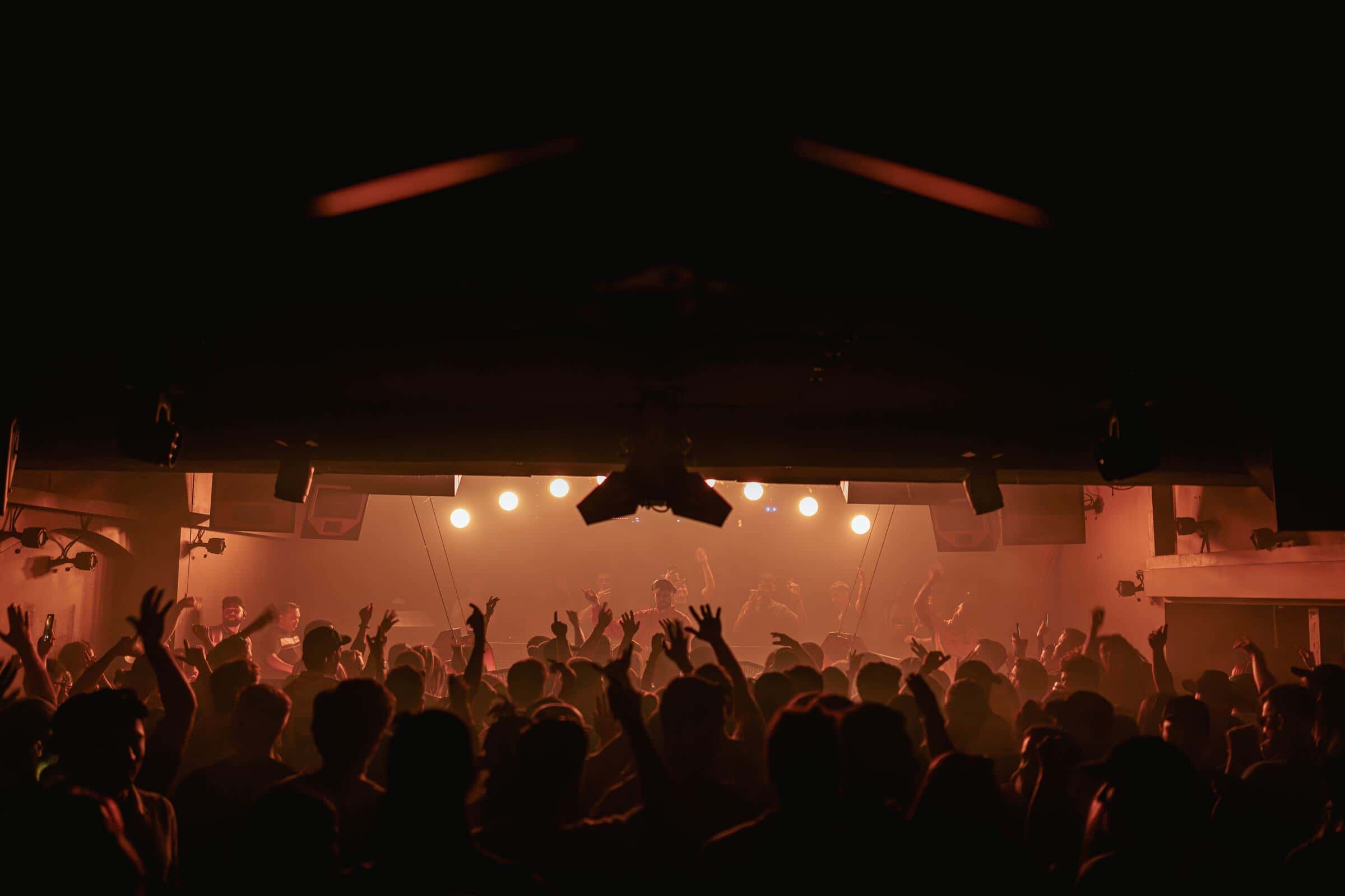 Carousel crowd facing the stage under amber haze
