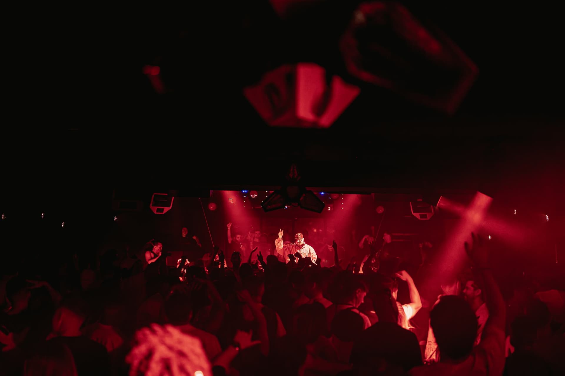 Performer leading the Carousel crowd under red light